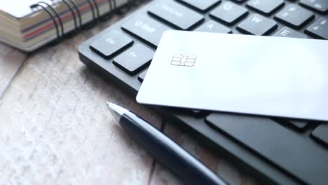 credit card on keyboard with office supplies