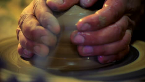 men hands work piece clay on potters wheel. making clay dishes