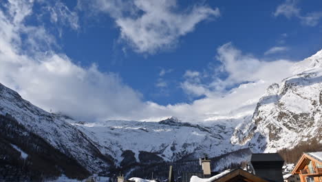 Timelapse:-Pueblo-De-Saas-Fee,-Cordillera-Con-Cumbres-Nevadas-De-Los-Alpes-Y-Un-Cielo-Con-Nubes-En-Movimiento,-Suiza