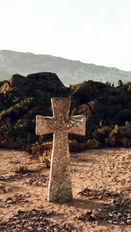 cruz de piedra en un paisaje desértico