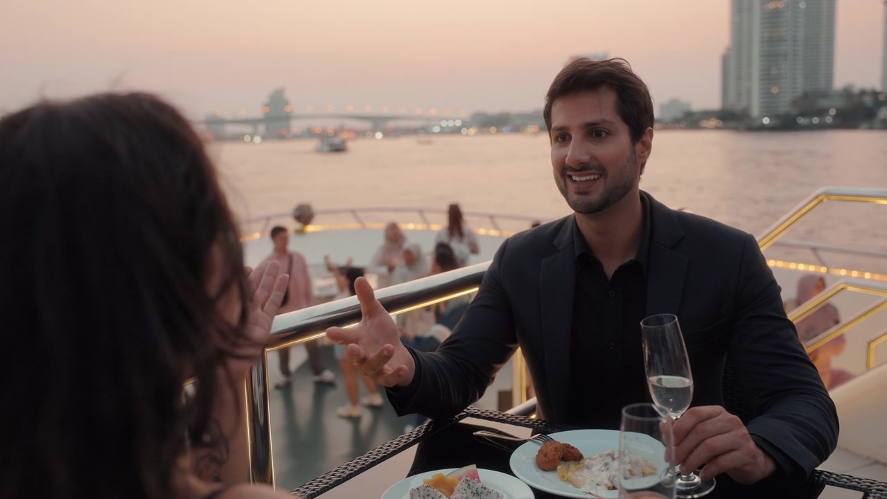 Coppia che si gode una cena romantica su uno yacht al tramonto