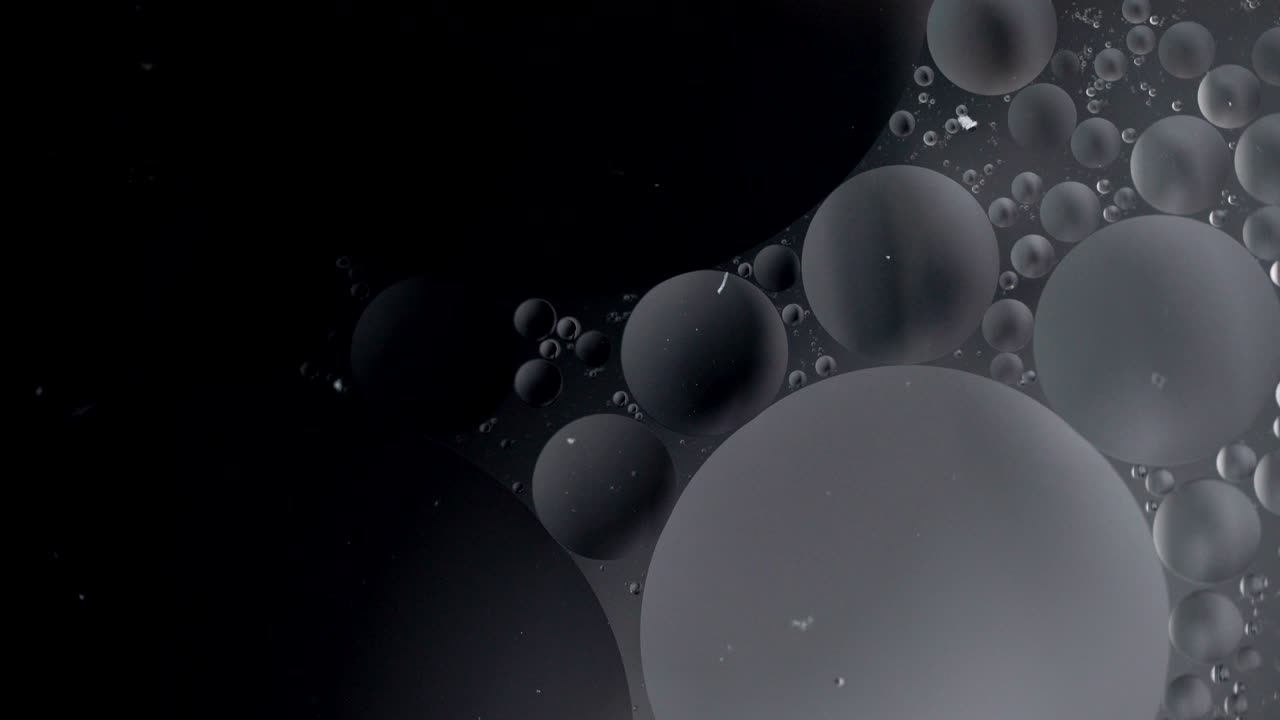 Fantastic structure of colorful bubbles. Chaotic motion. Abstract colorful paint. Top view. Movement of bubbles in the liquid. Oil surface multicolored background. Macro