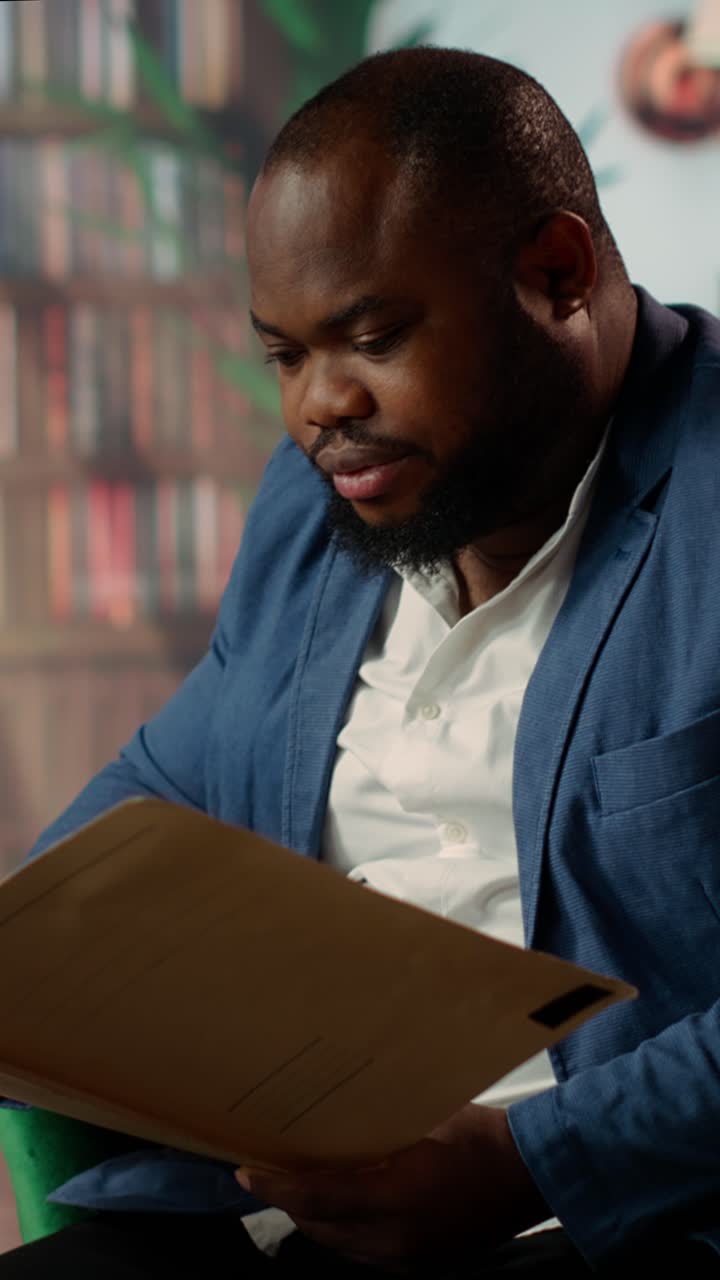 African American Businessman Talking and Reading Documents in Office