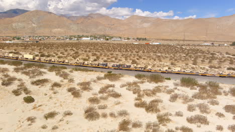 aerial flyover military vehicle transport train in the desert