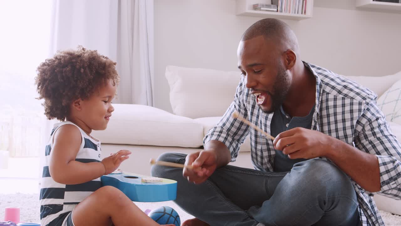 Young black dad and his young daughter playing instruments