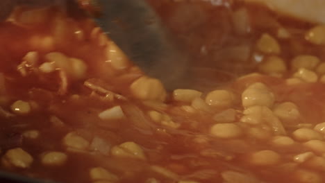 chick pea dish being stirred with a spoon macro