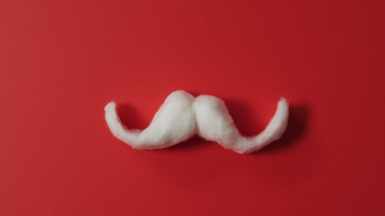 bigote de algodón blanco de santa claus sobre un fondo rojo
