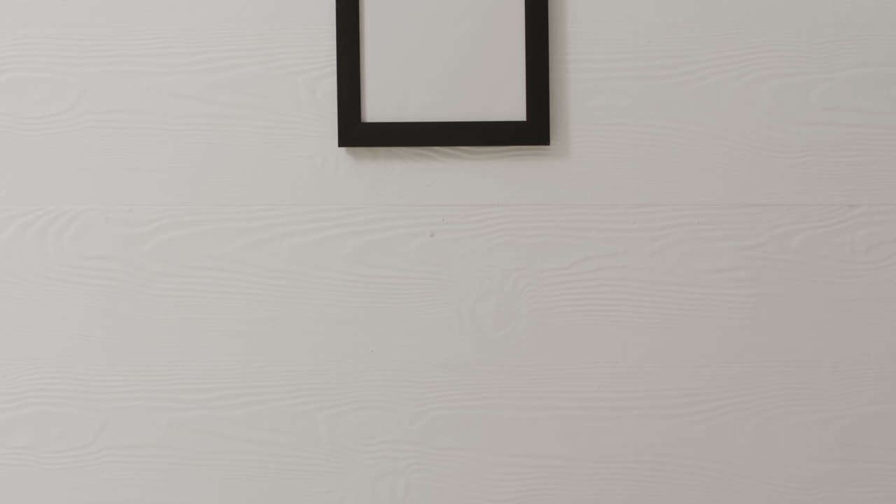 marco de madera con espacio de copia colgado en la pared blanca