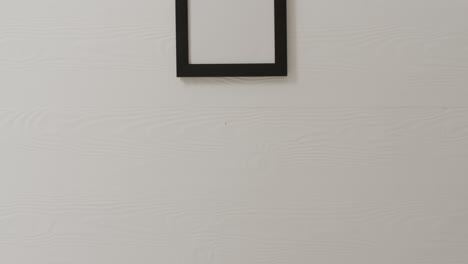 wooden frame with copy space hanging on white wall