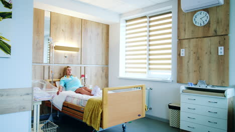 big light comfortable ward in the maternity hospital. pregnant lady lies on the bed under the drop counter. preparation before childbirth.