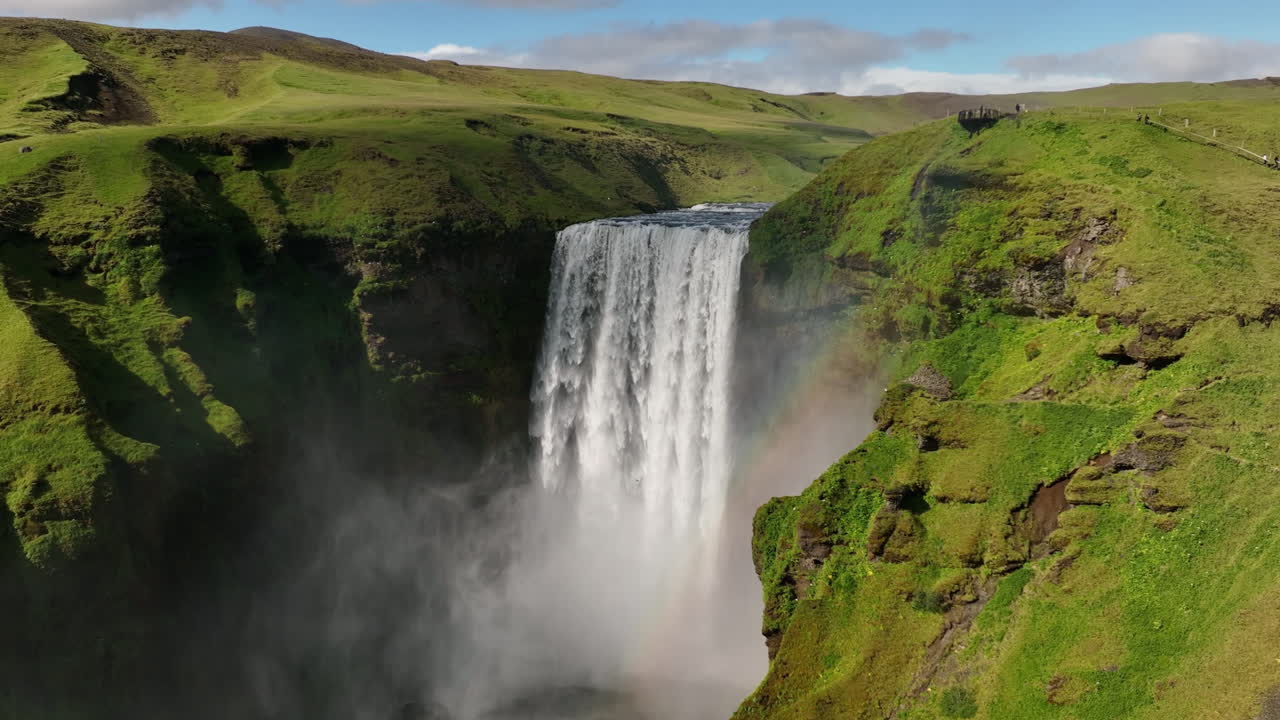gran cascada gigante en islandia cámara lenta aérea con arco iris día soleado