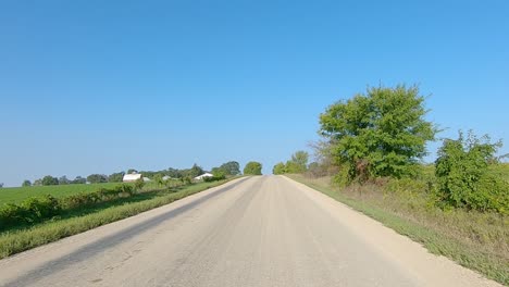 pov mientras conduce por campos y granjas en un camino de ripio en la zona rural de iowa a fines del verano