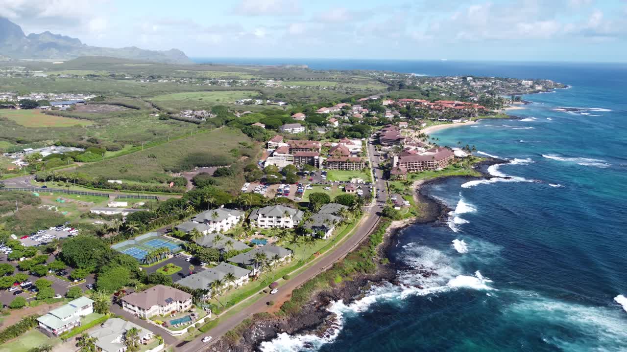 Splendida vista aerea che cattura hotel resort fronte oceano, spiaggia, oceano blu e paesaggio montano