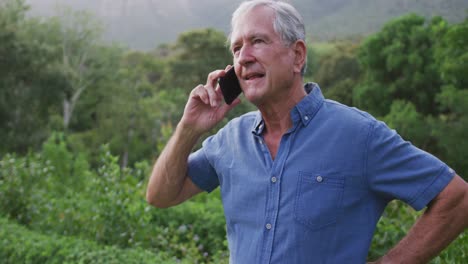 Hombre-Caucásico-Mayor-Sonriendo-Y-Hablando-Por-Teléfono-En-El-Jardín