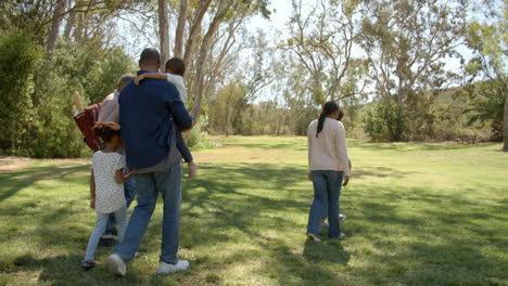 familia negra de varias generaciones preparándose para un picnic en un parque