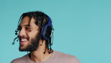 joyous man listening music, having fun, dancing, studio background