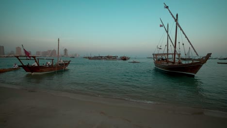 traditional arabic fishermen with dhows with qatar flag in arabic gulf