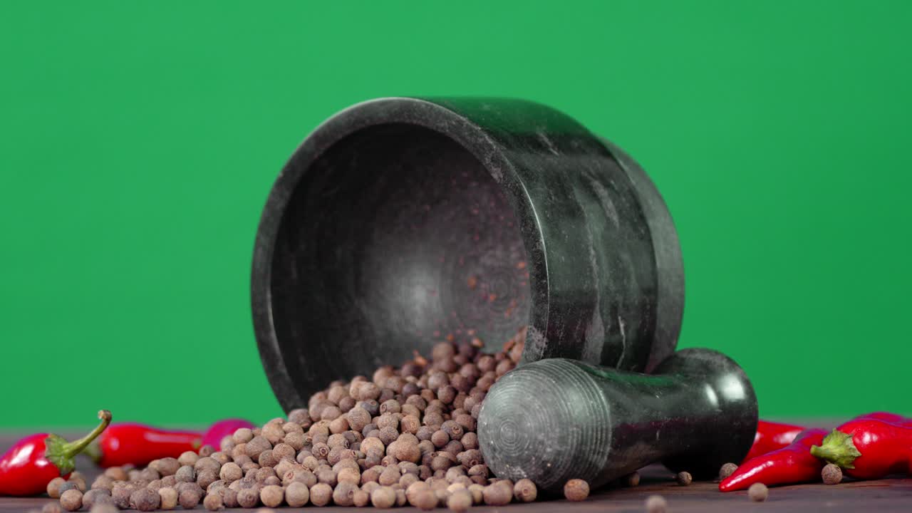 Peas of black pepper with mortar and pestle rotates slowly.