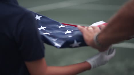 close up of american flag being folded up after the national anthem