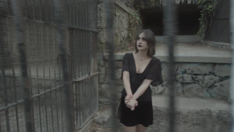 Zeitlupenclip-Eines-Gothic-Girl-Models-Hinter-Gittern-In-Einem-Gefängnis,-Das-Eine-Pirouette-Macht