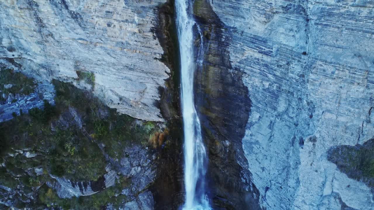 Cascata impetuosa che scorre lungo un ripido pendio roccioso.