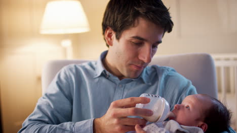 Father-In-Nursery-Feeding-Baby-Son-From-Bottle