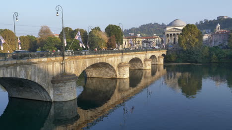 vittorio emanuele bridge across po river in turin, italy with church of gran madre di dio in background at daytime