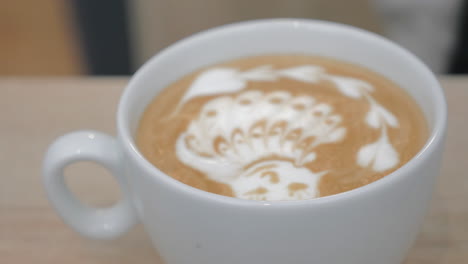 close-up shot of barista finishing cream picture on latte matcha