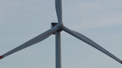 close-up shot of a wind turbine's blades rotating against a clear sky, highlighting the clean energy technology in a serene setting