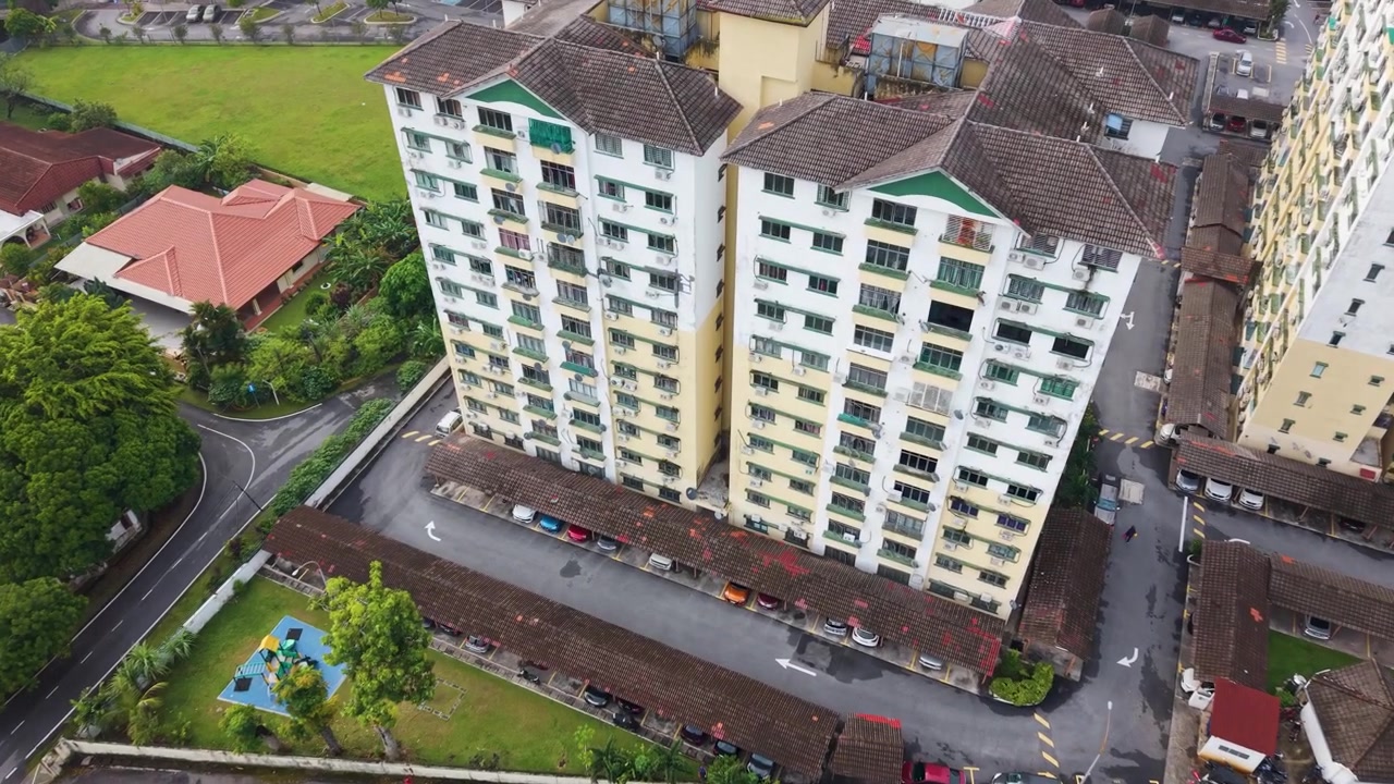Ripresa drone in avvicinamento di vecchi condomini residenziali a Petaling Jaya, Malesia, che mostra abitazioni urbane ad alta densità associate a redditi più bassi e comunità B40