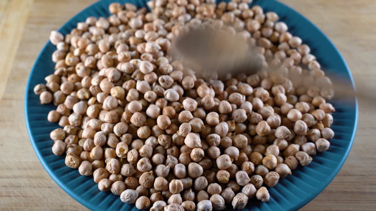 los garbanzos turcos esparcidos se clasifican con una cuchara de madera. legumbres, frijoles y lentejas de alta proteína para una dieta saludable.