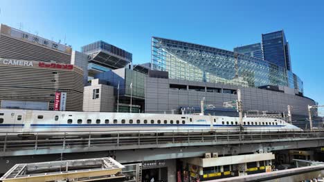 shinkansen bullet train passing through a modern urban landscape in japan