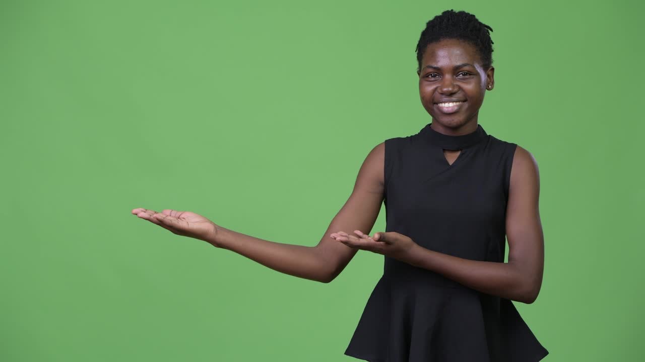 Young beautiful African businesswoman showing something