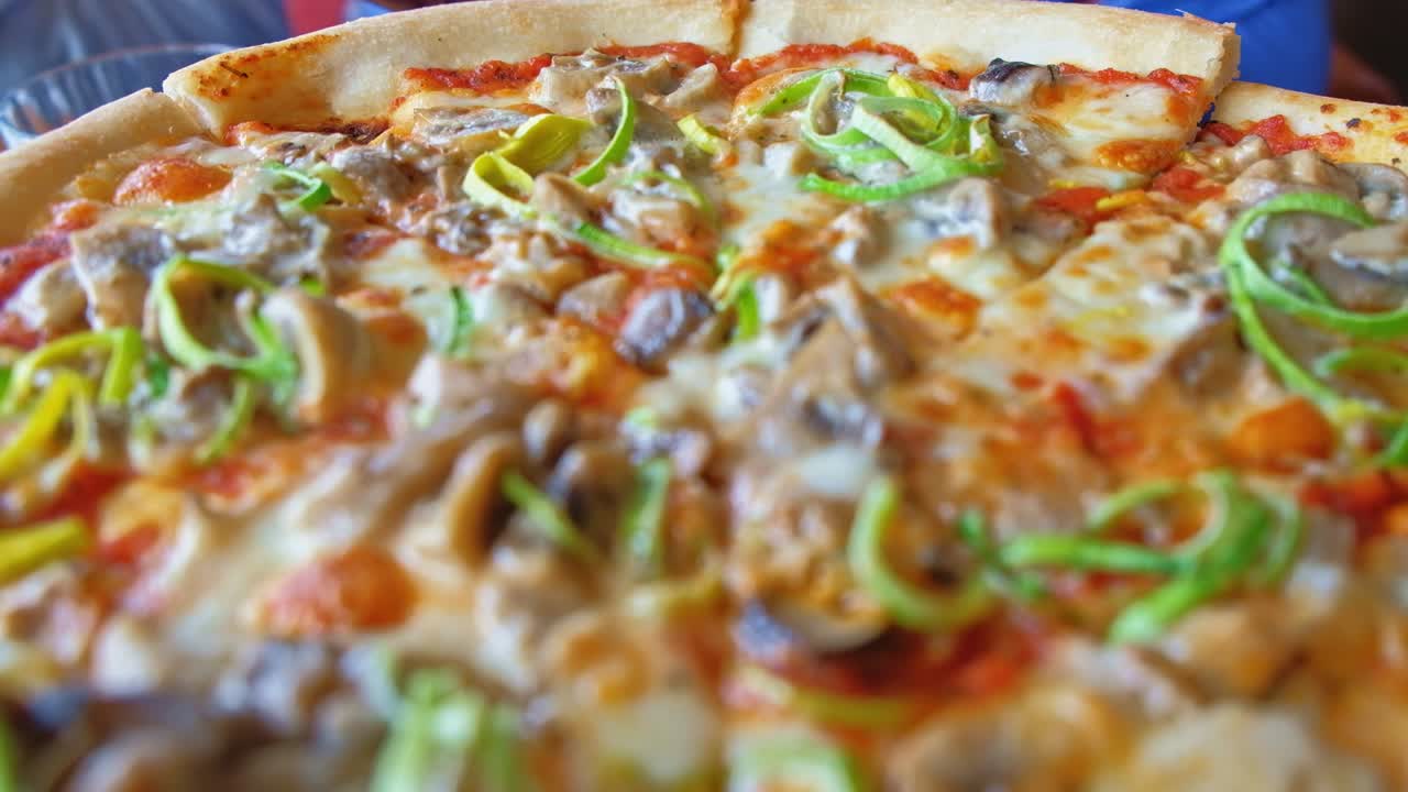 테이블에 매력적인 피자를 제공했습니다. 카메라 움직임 앞으로, 실시간, 클로즈업