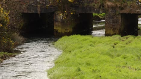 tomada media del río carnon con puente de carretera y llamarada solar