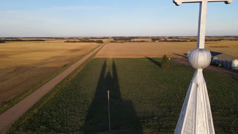 aerial pull back shot of roman catholic church in north american prairie during sunset