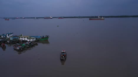 Vista-De-Seguimiento-Aéreo-De-Arriba-Hacia-Abajo-De-Barcos-De-Trabajo-Y-Embarcadero-En-El-Paseo-Marítimo-Del-Río-Saigón-A-última-Hora-De-La-Tarde