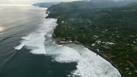 Aerial-view-moving-shot,-scenic-view-of-the-bitcoin-beach-in-El-Salvador,-Mexico,-sunset-reflecting-on-the-beach-in-the-background