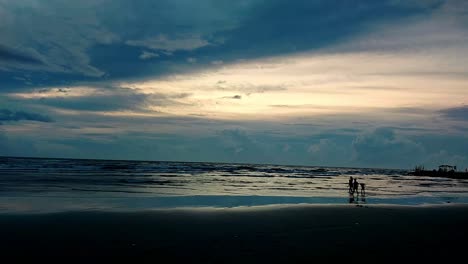 Siluetas-De-Niños-Jugando-Alegremente-En-La-Playa-En-Una-Majestuosa-Puesta-De-Sol-Azul-En-Dipolog-Filipinas,-Vista-Amplia