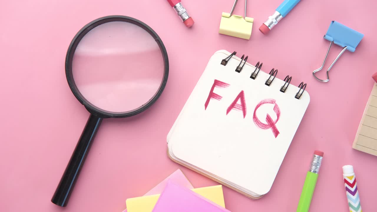 핑크색 배경에 학교 용품이 있는 faq 노트북