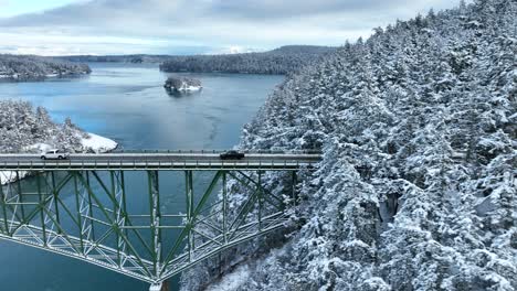 drone shot of a black truck driving across deception pass in washington state