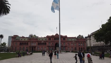 establisher at the pink house government house of argentina, people walk at plaza de mayo
