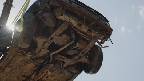 car vehicle suspended from a crane, low angle, sunbeams sunny day, static