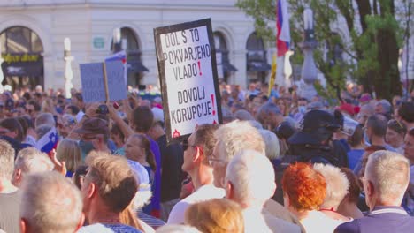 policemen walk through crowd of protesters in the street during statehood day in ljubljana, slovenia. tracking shot