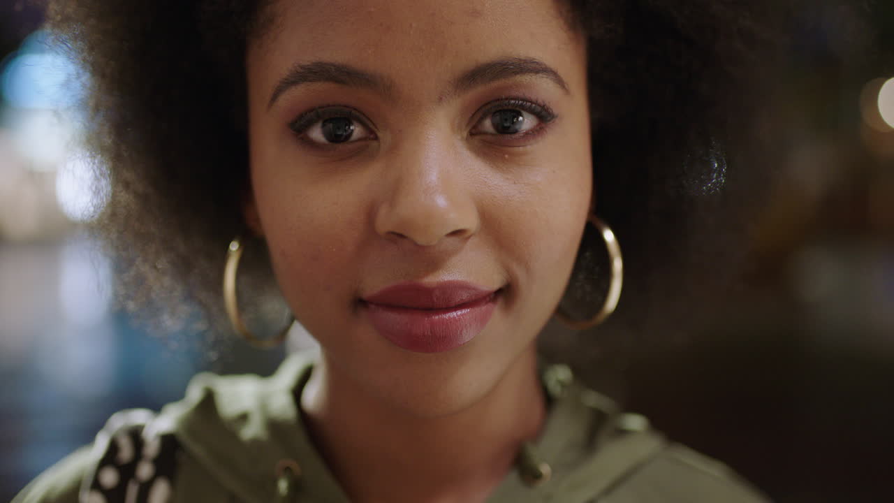 retrato en primer plano de una mujer afroamericana de moda con afro sonriendo feliz mirando a la cámara sintiéndose confiada