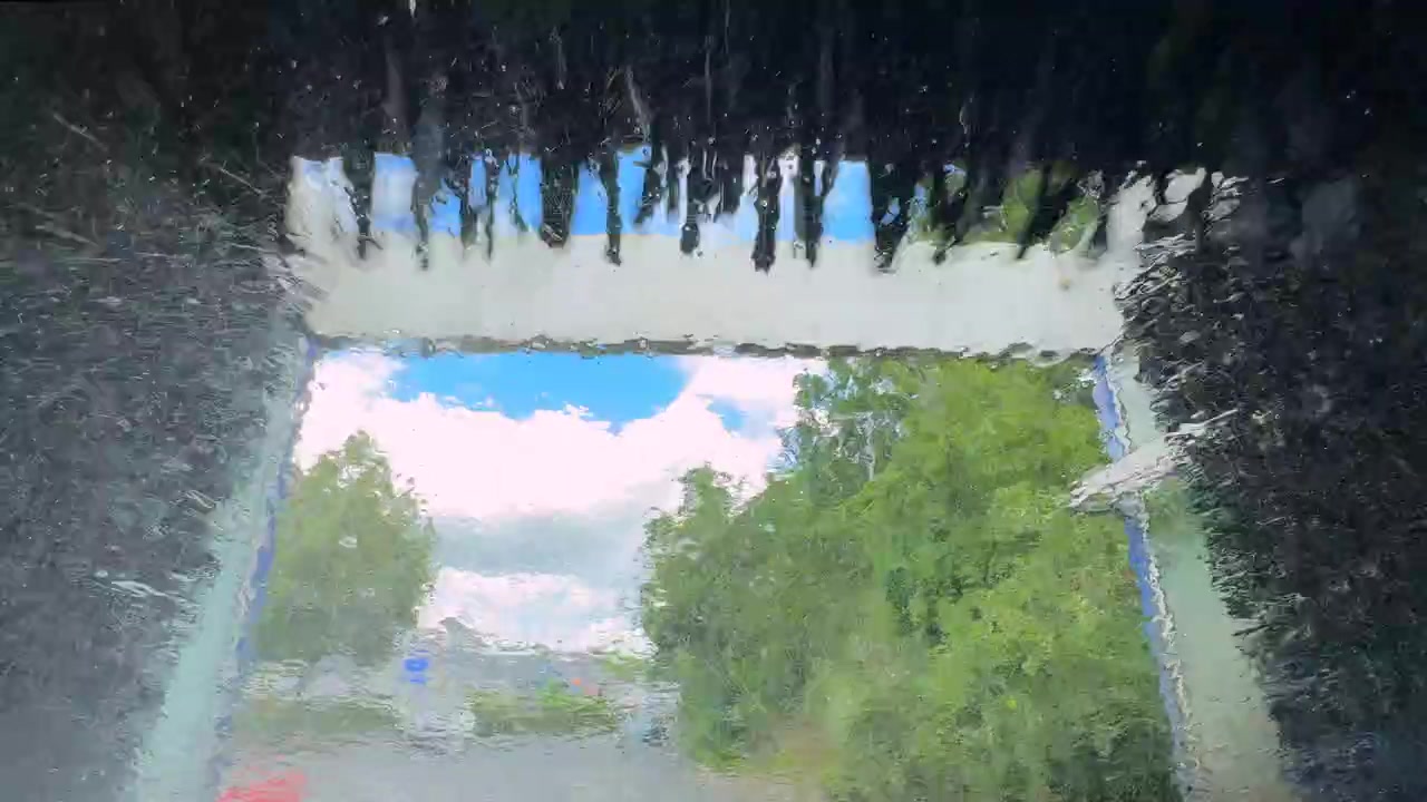 A drive through car was operating with it's jets of water and rotating brushes seen through the from window of a car, Worcestershire, England.