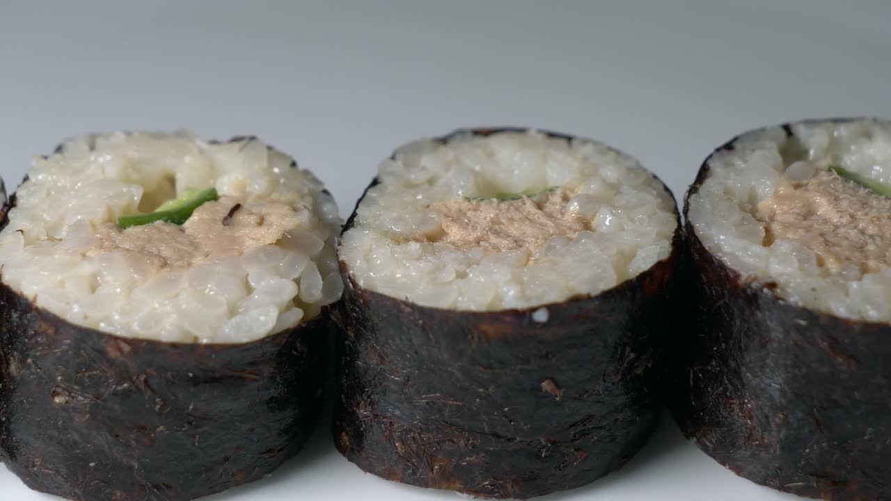 rollos de sushi servidos profesionalmente con atún, aguacate y arroz en un restaurante japonés