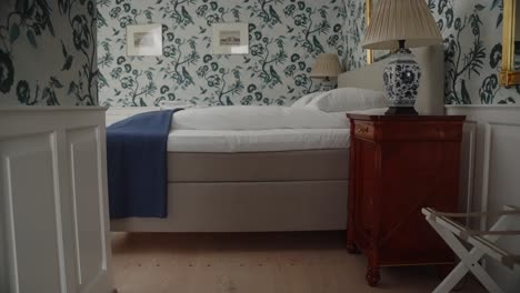 4k slow motion gimbal push in on traditional and luxurious bedroom in a danish castle with upper class furniture, bed and decorations and tapestry on the walls