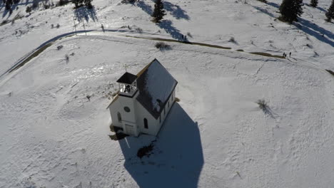 antena de la iglesia en un campo montañoso cubierto de nieve, retírese para revelar el paisaje