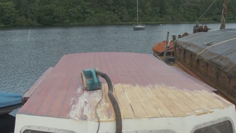 timelapse of young carpenter removing varnish on wooden boat wheelhouse roof